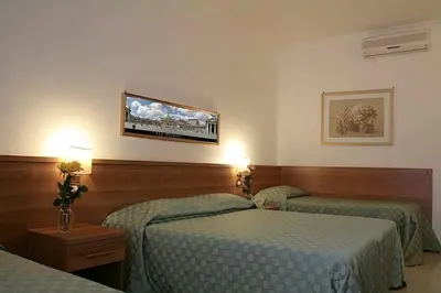 a hotel room with two beds and a tv on the wall at Emanuela Guest House in Rome