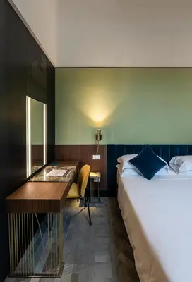 a hotel room with a bed and a desk at Horti 14 Borgo Trastevere Hotel in Rome