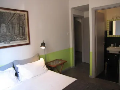 a bedroom with a bed and a bathroom with a sink at Trastevere Colors in Rome