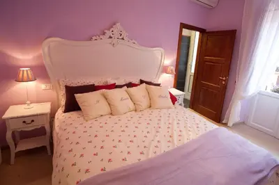 a bedroom with a large bed with a white headboard at Il Mondo Di Amelia in Rome