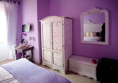 a purple bedroom with a bed and a mirror at Il Mondo Di Amelia in Rome