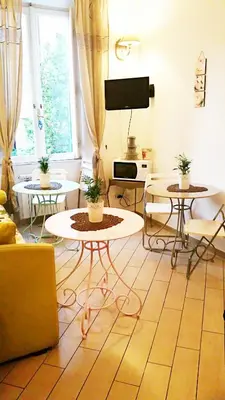 a living room with two tables and a tv at Il Mondo Di Amelia in Rome