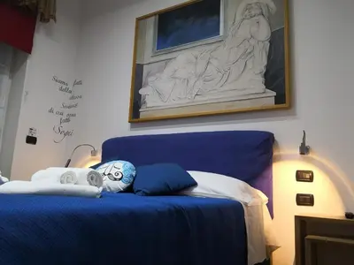a bedroom with a blue bed with a statue on the wall at CoPPoLaMyHouse in Rome