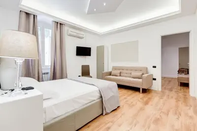 a white bedroom with a bed and a couch at Vaticano Private Apartment in Rome