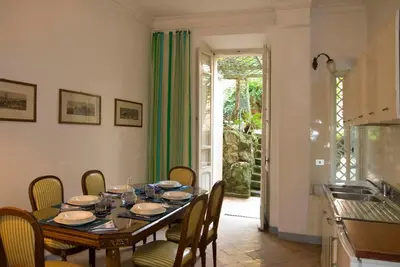 a dining room with a table and chairs and a kitchen at Il Mio Giardino in Rome