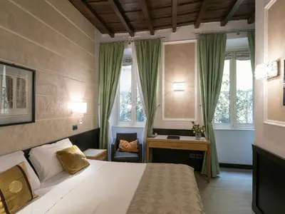 a bedroom with a bed and a desk and windows at DK Suites in Rome