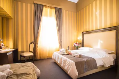 a hotel room with two beds and a window at Domus RomAntica in Rome