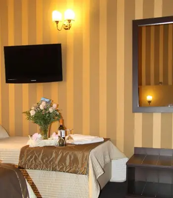 a room with a bed with a vase of flowers on a table at Domus RomAntica in Rome
