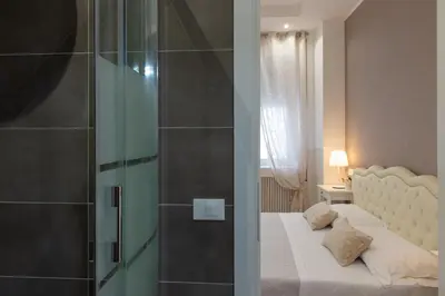 a bedroom with a bed and a glass shower at Domus St. John in Rome