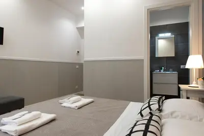 a bedroom with two white towels on a bed at Domus St. John in Rome