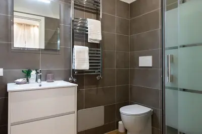 a bathroom with a toilet and a glass shower at Domus St. John in Rome