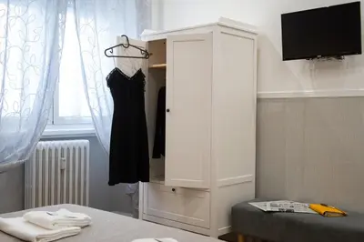 a white cabinet with a dress hanging in a room at Domus St. John in Rome