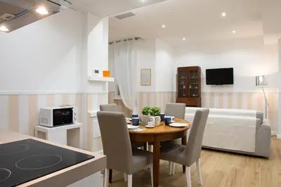 a living room with a table and chairs and a couch at Domus St. John in Rome