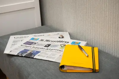 a newspaper and a yellow book and a pen at Domus St. John in Rome