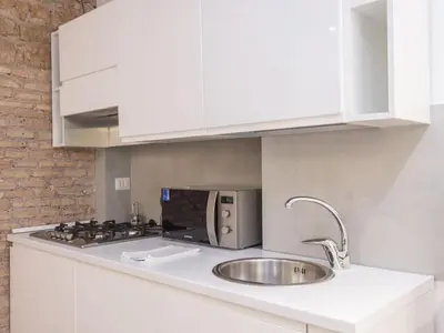 a white kitchen with a sink and a stove at Apartment Forum Augusti by Interhome in Rome
