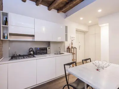 a kitchen with white cabinets and a table with chairs at Apartment Forum Augusti by Interhome in Rome