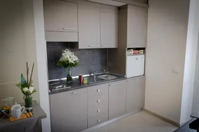 a kitchen with white cabinets and a sink at Castellani A San Pietro in Rome