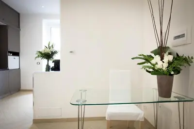 a glass table in a kitchen with a vase of flowers at Castellani A San Pietro in Rome