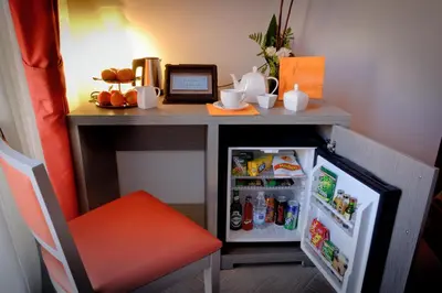 a desk with an open refrigerator and a red chair at Castellani A San Pietro in Rome