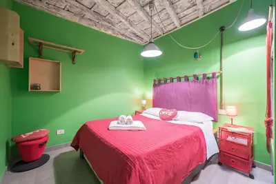 a green bedroom with a bed with a red blanket at Quirinale Apartments in Rome