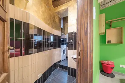 a bathroom with a toilet and a green wall at Quirinale Apartments in Rome