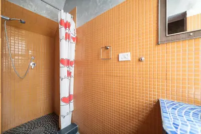a bathroom with a shower with orange tiled walls at Quirinale Apartments in Rome
