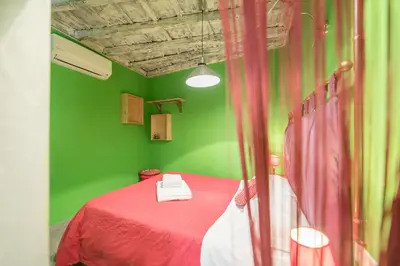 a green room with a bed with a red blanket at Quirinale Apartments in Rome