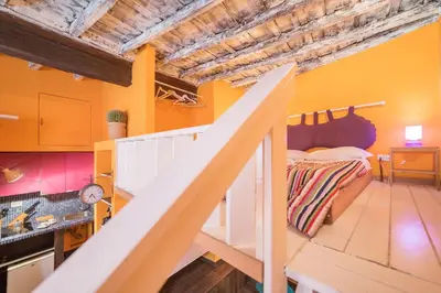 a bedroom with yellow walls and a staircase with a bed at Quirinale Apartments in Rome