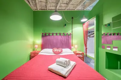 a green bedroom with a bed with two towels on it at Quirinale Apartments in Rome