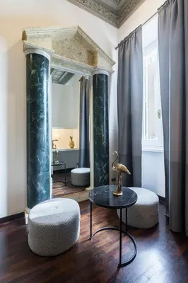 a room with a mirror and a table and chairs at San Carlo Suite in Rome