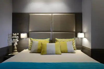 a bedroom with a large bed with yellow and white pillows at San Carlo Suite in Rome
