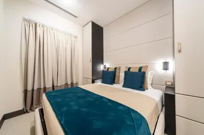 a bedroom with a large bed with blue pillows at San Carlo Suite in Rome