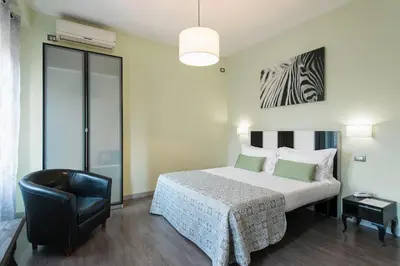 a bedroom with a bed and a black chair at B&B Blueberry Rooms in Rome