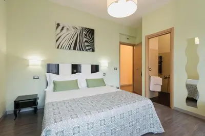 a bedroom with a large white bed and a painting on the wall at B&B Blueberry Rooms in Rome