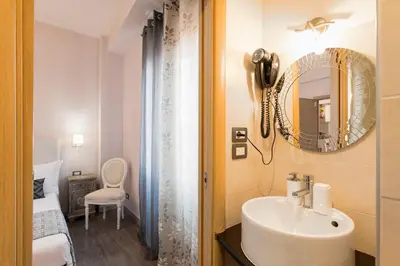a bathroom with a sink and a mirror and a bed at B&B Blueberry Rooms in Rome