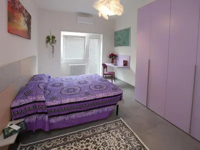 a bedroom with a purple bed and a window at Appartamento Turistico Laura in Rome