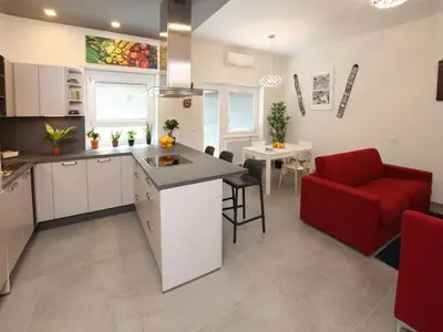 a kitchen and a living room with a red couch at Appartamento Turistico Laura in Rome