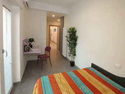 a bedroom with a bed and a desk and a chair at Appartamento Turistico Laura in Rome