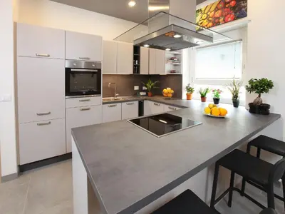 a kitchen with white cabinets and a large counter top at Appartamento Turistico Laura in Rome