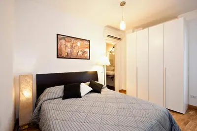 a bedroom with a bed and a large white cabinet at Romacentrarte in Rome