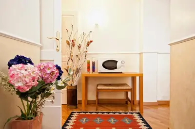 a room with a table with a microwave and flowers at Romacentrarte in Rome