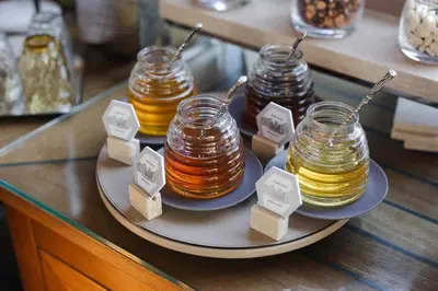 a plate with four jars of honey on a counter at Portrait Roma - Lungarno Collection in Rome