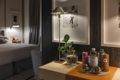 a room with a bed and a table with a lamp at Portrait Roma - Lungarno Collection in Rome