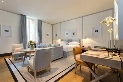 a hotel room with a bed and a table and chairs at Portrait Roma - Lungarno Collection in Rome
