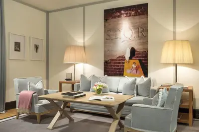 a living room with a couch and a table and chairs at Portrait Roma - Lungarno Collection in Rome