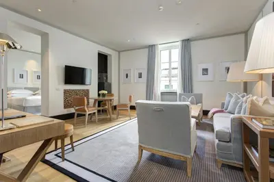 a hotel room with a living room and a bedroom at Portrait Roma - Lungarno Collection in Rome