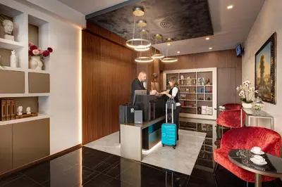 a man and a woman standing at a counter in a lobby at Dharma Luxury Hotel & SPA in Rome