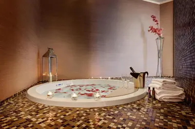 a bathroom with a tub with a vase of flowers at Dharma Luxury Hotel & SPA in Rome