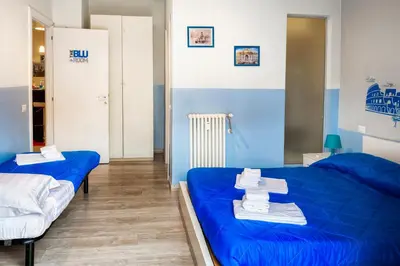 two beds in a room with blue walls at The Colours Of Rome in Rome