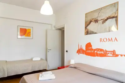 a bedroom with two beds and a painting on the wall at The Colours Of Rome in Rome